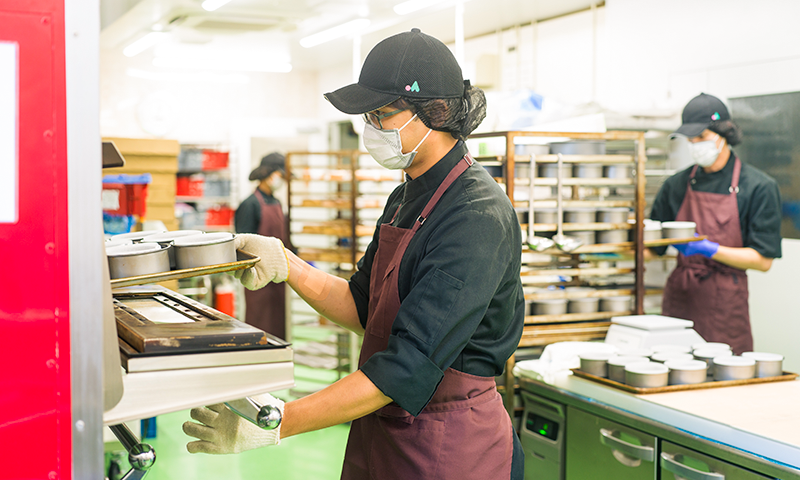 材料を焼釜に入れる男性