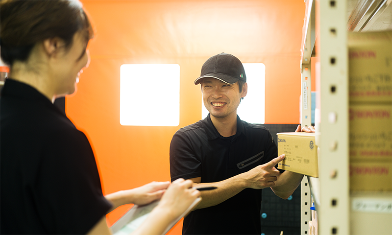 倉庫で案内をする男性